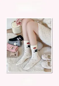 Close-up of cotton crew socks featuring cute cartoon cat jacquard and polka dot patterns