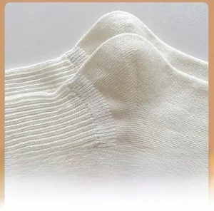 Detail shot of the white cotton knit sock heel featuring fine texture and ribbed cuff