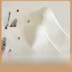 Détail du talon de chaussette en coton avec motif d'ours mignon et pois marrons