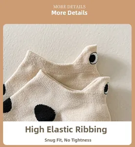 Detail view of cotton ankle sock with black polka dots and embroidered eye heel tab