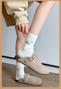 Détail de chaussette en coton blanc avec motif de chien brun et texture côtelée