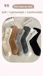 Detailed view of six pairs of ribbed cotton socks with elegant bow embroidery details