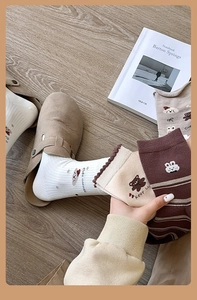 Détail de chaussettes en coton avec motifs d'ours mignons aux tons neutres et chauds