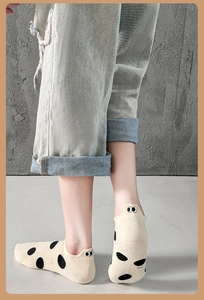 Detail of beige low-cut cotton socks with black dots and cartoon eye embroidery