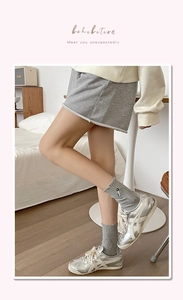 Close-up of grey ribbed cotton socks with metal pin detail and silver sneakers