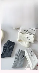 Detailed view of four pairs of distressed cotton socks with pin embroidery and raw edges
