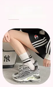 Detail of white combed cotton socks featuring black and gray stripes and ribbed cuffs