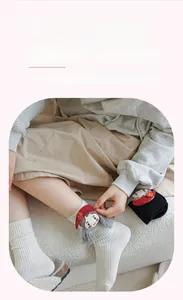 Close-up of ribbed cotton mid-calf socks featuring 3D cartoon doll and ruffled cuffs