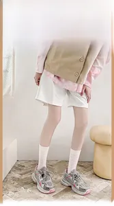 Dettaglio di sneaker retrò grigie e rosa con suola spessa e calze di cotone a righe