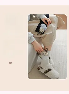 Detail of plush cream slippers and white knitted socks with 3D bunny decoration