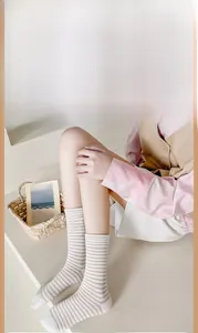 Dettaglio di calze di cotone a righe rosa e bianche indossate con bordo elastico