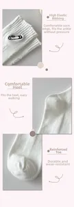 Detailed view of white cotton socks featuring safety pin embroidery and reinforced heel