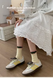 Detail of yellow ribbed socks featuring pink and green ruffled cuffs and color block trim