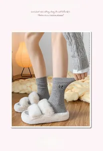 Detail of grey ribbed cotton socks featuring black bow embroidery and comfortable elastic cuffs