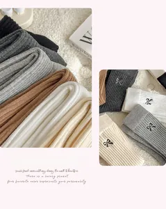 Detail of cotton crew socks featuring elegant black bow embroidery and ribbed knit texture