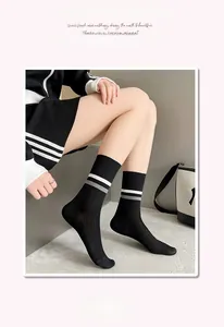 Detail of black ribbed crew socks for women featuring white stripes and elastic cuff