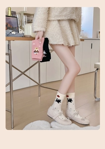 Detailed view of soft cotton socks with cute cartoon cat and bear patterns on ribbed cuffs