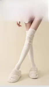Close-up of white ribbed over-the-knee socks showing soft cotton texture and elastic cuffs