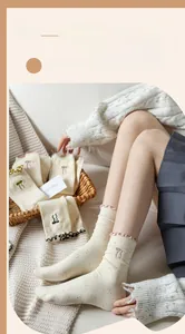 Detailed close-up of beige cotton socks featuring colorful dots and bow embroidery accents