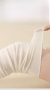 Detailed close-up of cream white breathable mesh fabric with high elasticity over-the-knee socks