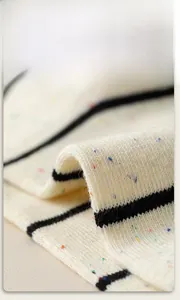 Detail shot of soft rib-knit cotton socks with colorful specks and black horizontal stripes
