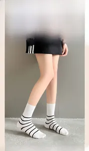White crew socks with black stripes shown on a model with minimalist Japanese style aesthetic