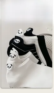 Detail of cotton socks featuring panda embroidery and elastic cuffs in a mesh basket