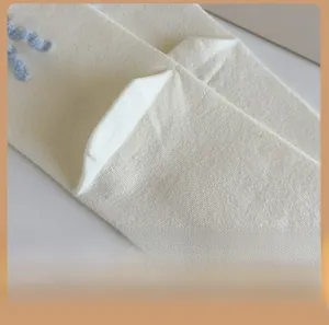 Gros plan détaillé de chaussettes en coton crème avec texture fine et broderie bleue
