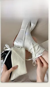 Detail of knit ribbon bow socks in white showing texture and elastic cuff fit