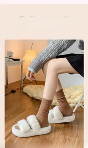 Detail of brown ribbed cotton socks with bow accent and cozy winter slippers