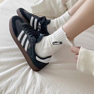 Black leather sneakers with white stripes and embroidered pin hole cotton socks