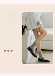 Close-up of grey knit socks with embroidered bows paired with Mary Jane shoes