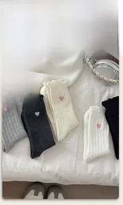 Détail de chaussettes en coton avec broderie coeur et bords à volants élégants