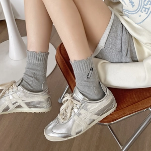 Gray cotton crew socks with pin embroidery and silver metallic low-top sneakers