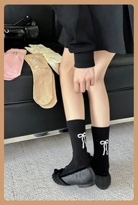 Gros plan de chaussettes mi-hautes pour femmes avec broderie nœud blanc élégante