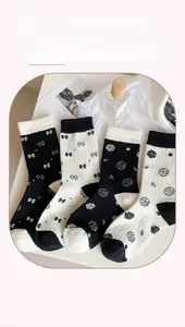 Flat lay of four pairs of cotton crew socks with bow and camellia patterns