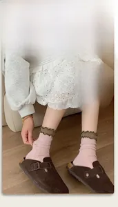 Detailed view of pink ribbed cotton socks featuring contrast dark olive ruffled cuffs