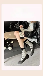 Close-up of white knitted cotton socks featuring black rose patterns in a lifestyle setting
