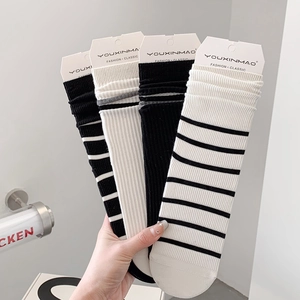 Pack of four white and black striped cotton crew socks with ribbed cuffs and tags