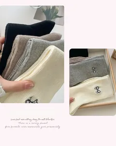 Detail of embroidered bow on cotton socks featuring tight knit texture and soft fabric