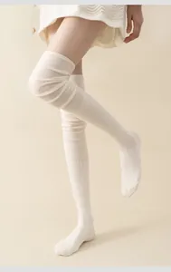 Detail of white thigh-high ribbed cotton socks with soft knit texture for women