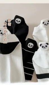 Close-up of panda embroidery and ribbed texture on black and white cotton socks