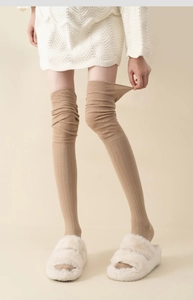 Detail of camel over-knee socks showing high-elasticity ribbed knit fabric and cozy texture