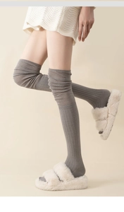 Detailed view of grey over-the-knee cotton socks with a ribbed knitted texture for women