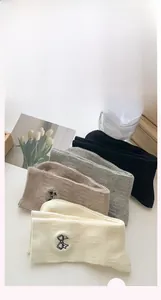 Detail showing embroidered black bow on various colored cotton socks in Japanese style