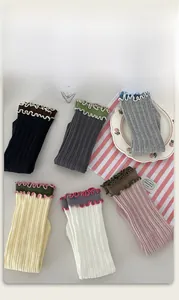 Flat lay of colorful ribbed cotton socks with ruffle edges on a decorative background