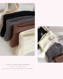 Close-up of ribbed cotton socks with sparkling rhinestone bows in four neutral colors