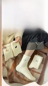 Detail of soft winter socks with cute animal embroidery featuring fox and cat patterns