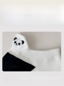 Detail of pandas embroidery and high-elastic cuff on black and white cotton socks