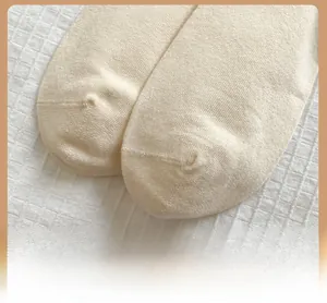 Detail shot of the reinforced toe construction on cream-colored knitted cotton socks